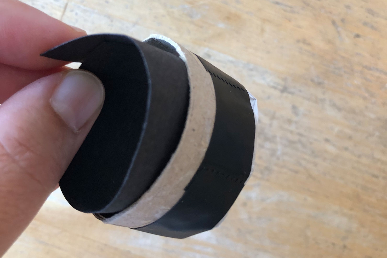 Ein Streifen Tonpapier wird in die gebastelte Lochkamerakappe geschoben.