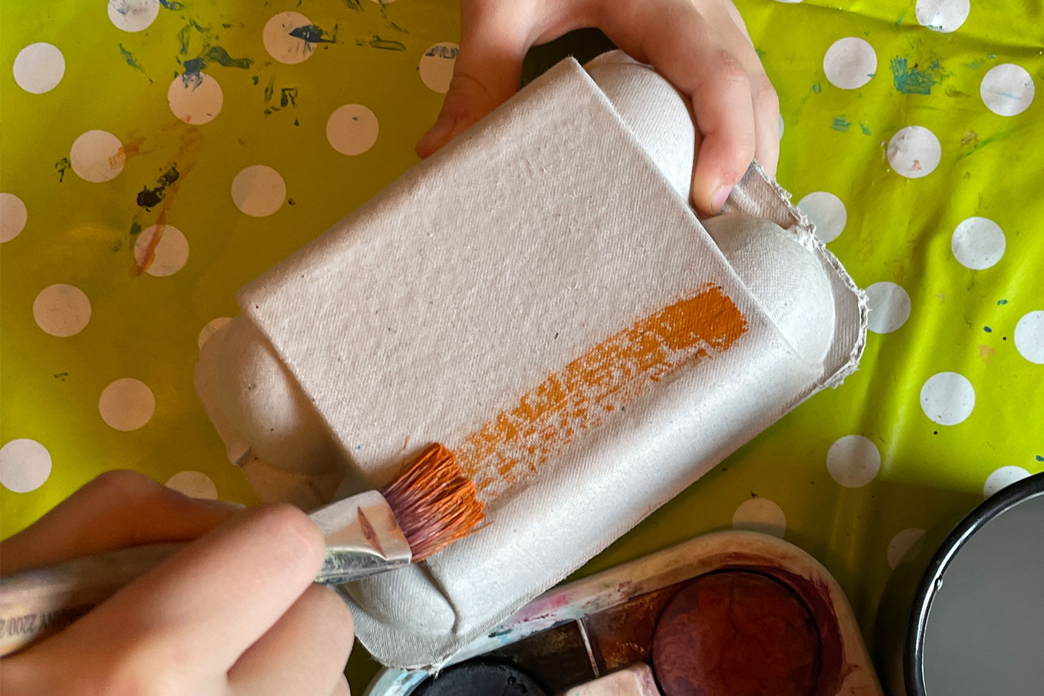 Die Außenseite des Eierkartons wird mit einem Pinsel in braun bemalt