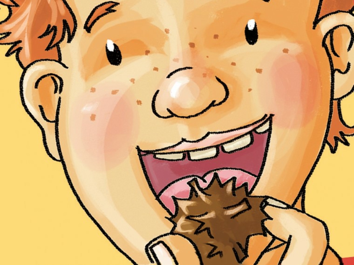 Kind mit großem Lächeln hält einen Schokocrossie in der Hand