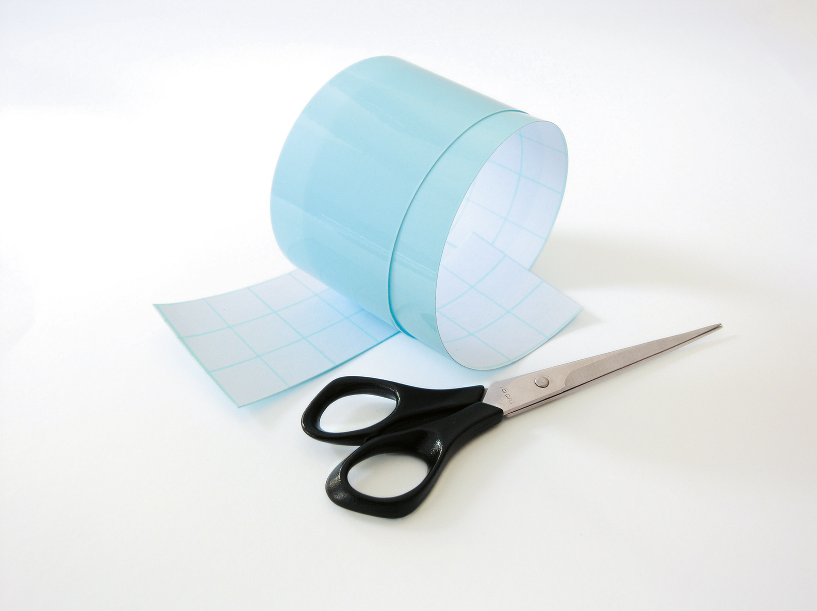 Papierstreifen und Schere als Bastelmaterial für Fanrasseln.