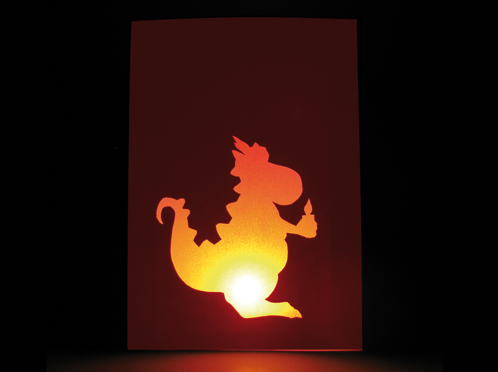 Windlicht leuchtet in dunkler Umgebung mit leuchtendem Drachenmotiv.