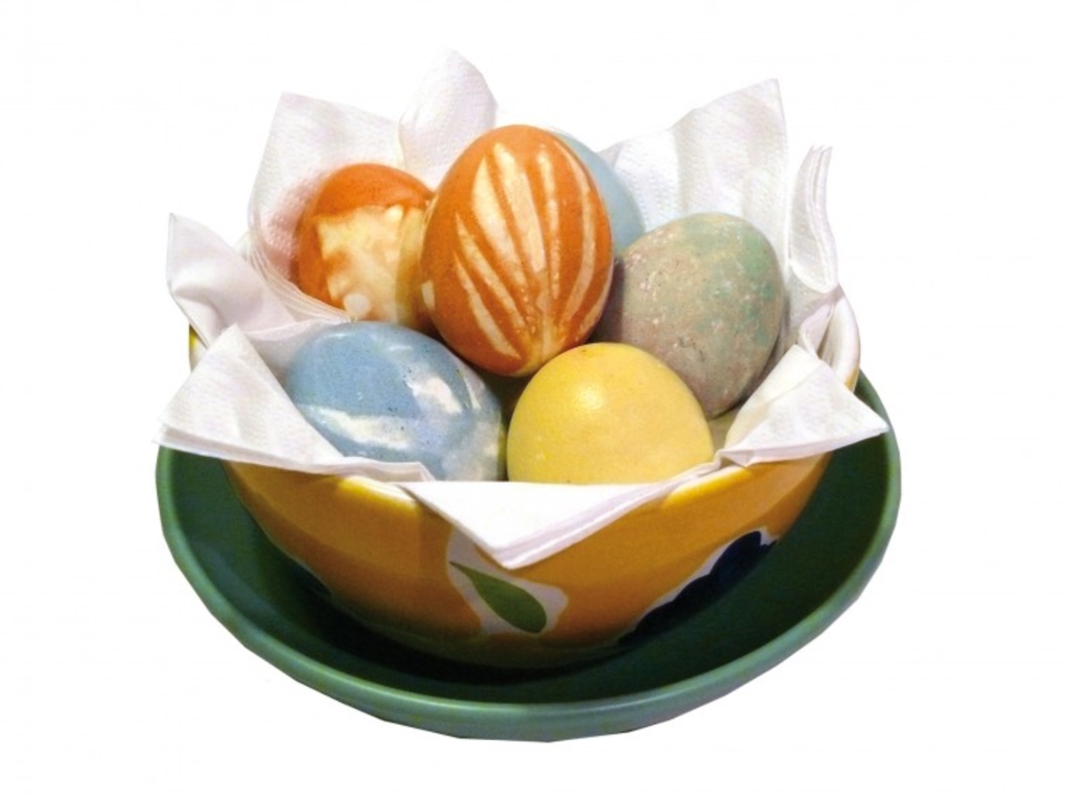 Gefärbte Ostereier mit Zwiebelschale in einer grünen Blattschale.